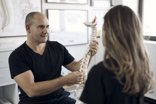 Chiropractor educating client about spine